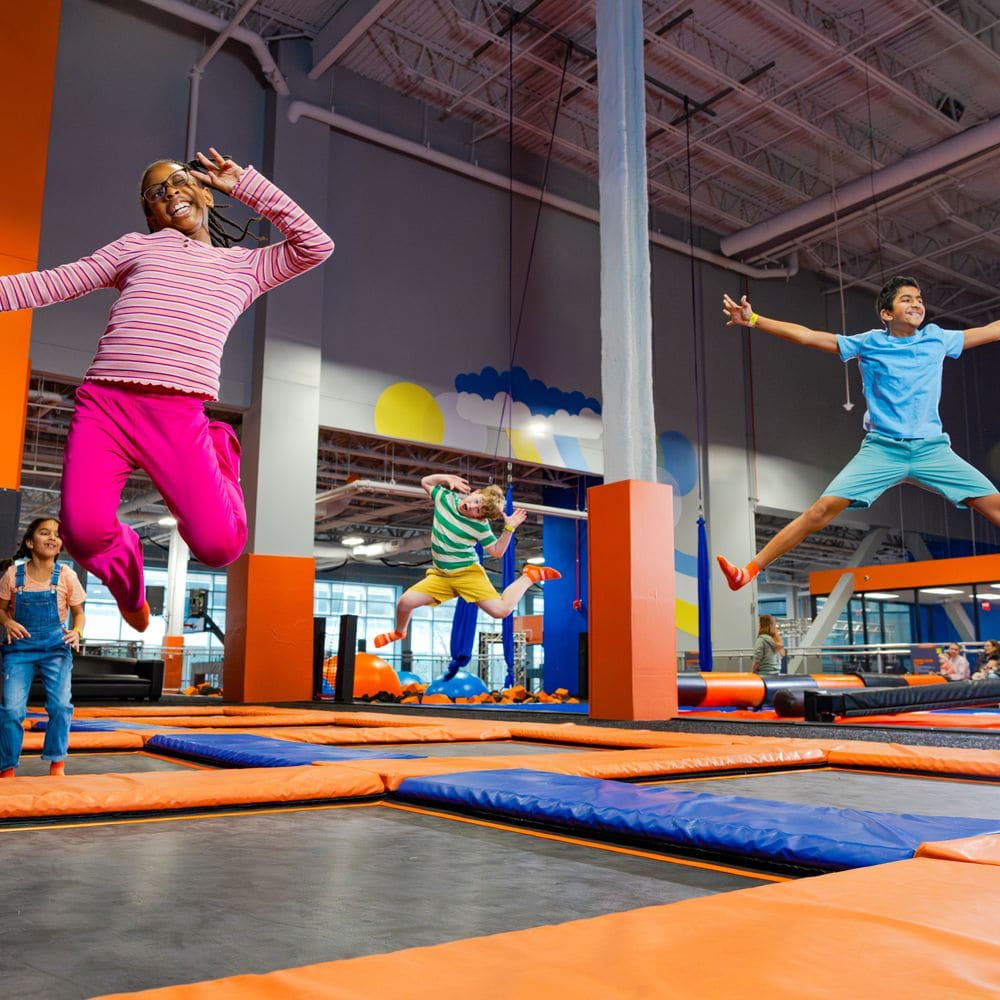 Kids bouncing on connected trampolines at Alias Park